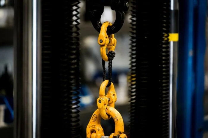 Yellow hydraulic pull-test rig hooks used to batch test Saber kinetic ropes to destruction