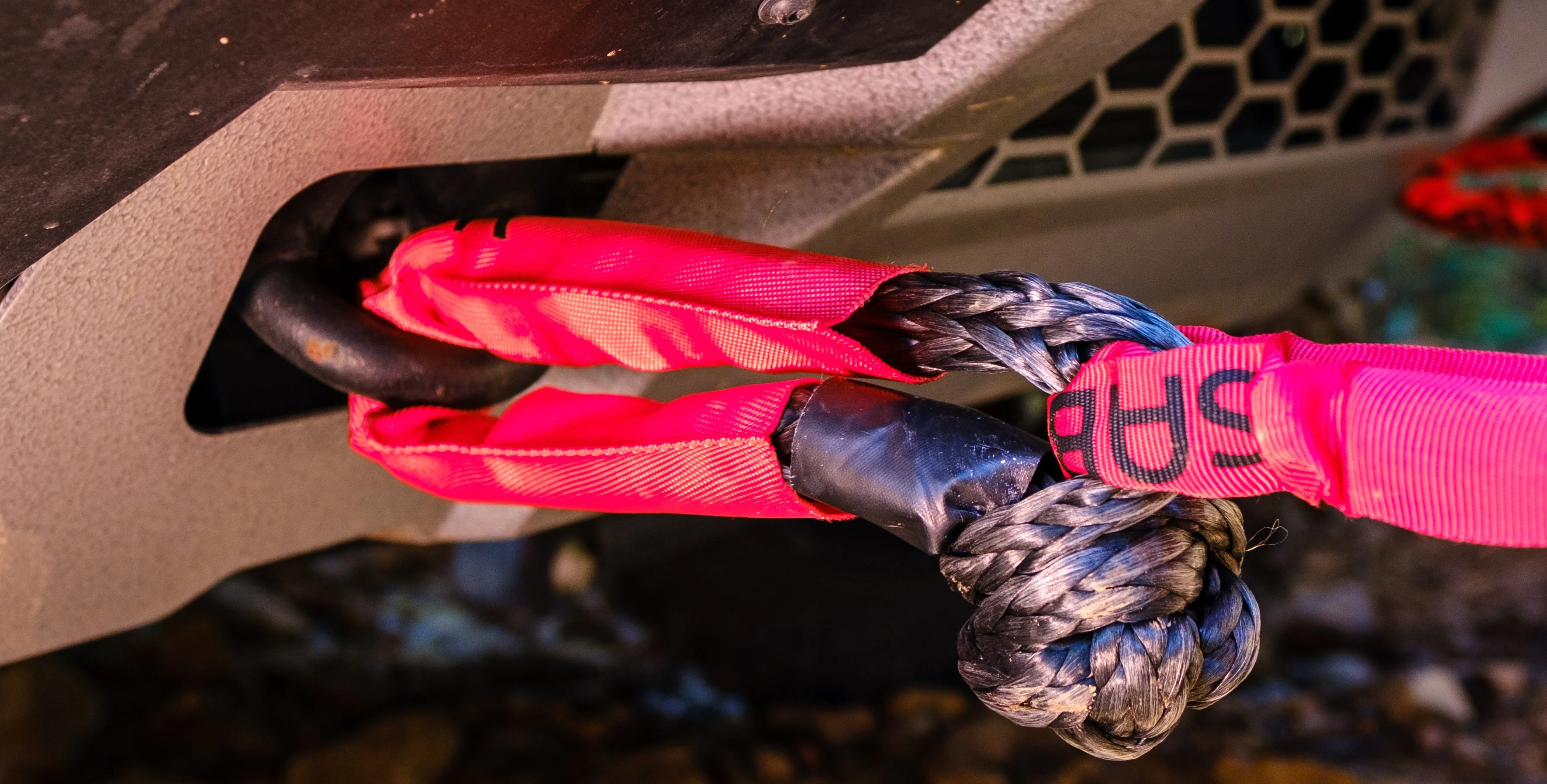 Pink Saber soft shackle rigged through a rounded recovery point on an Ineos Grenadier's bumper